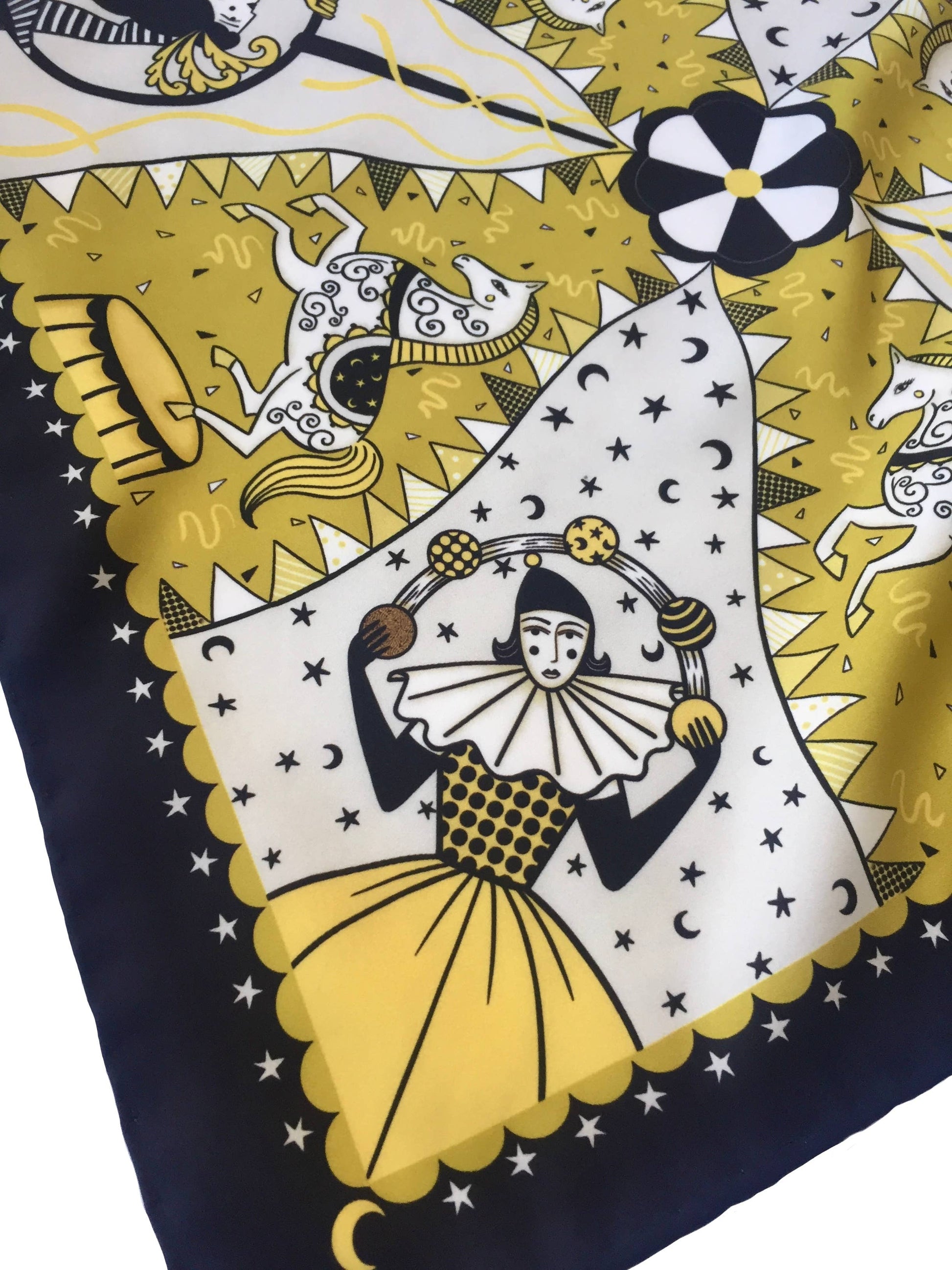 Eco silk twill pocket square with original Night Circus print by Su Owen; features Pierrot juggler, aerialist, horses, moons, and stars. Golden yellow, ivory, and dark chocolate colours. Made from 100% recycled polyester.