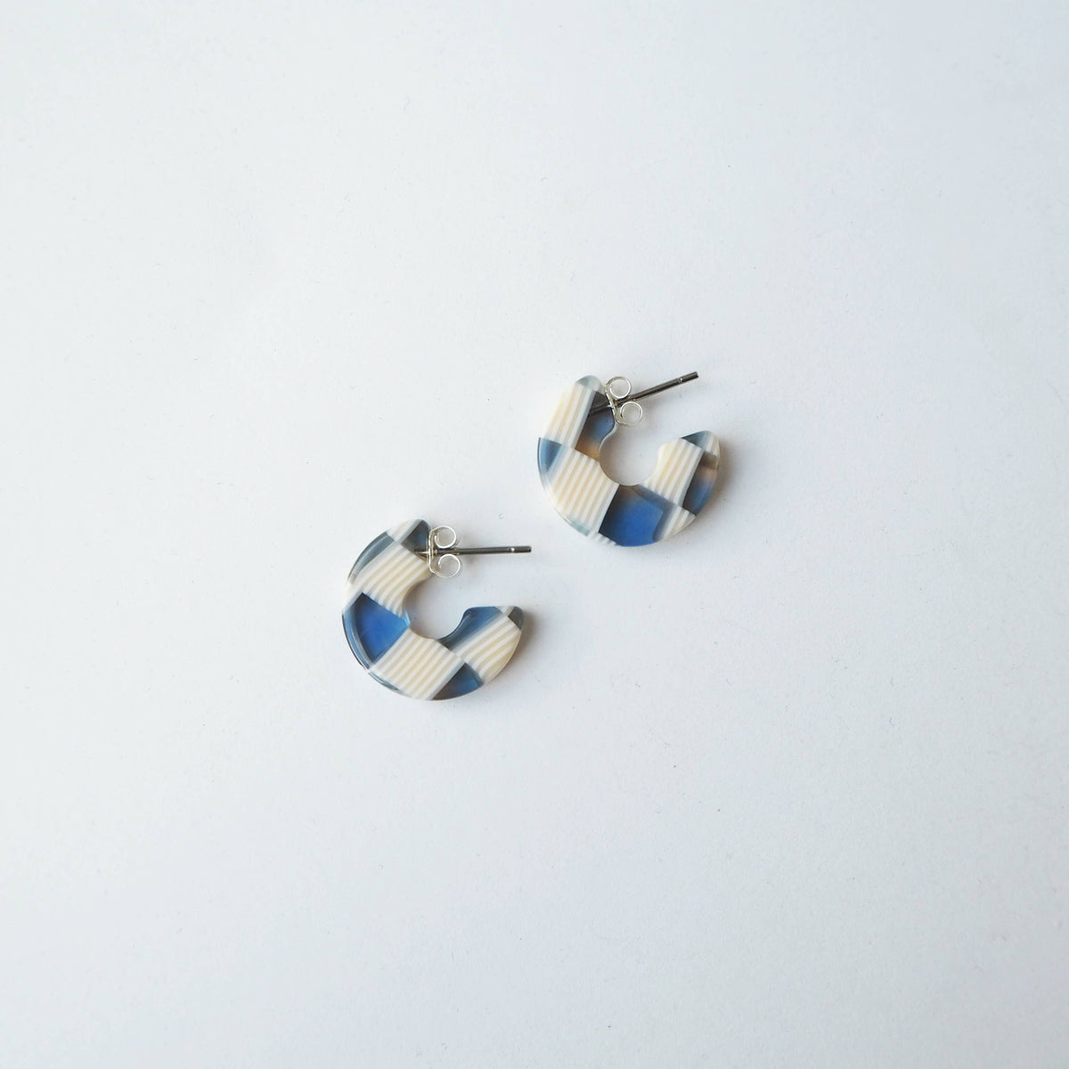 Close up of blue and cream checkerboard mini hoop earrings
