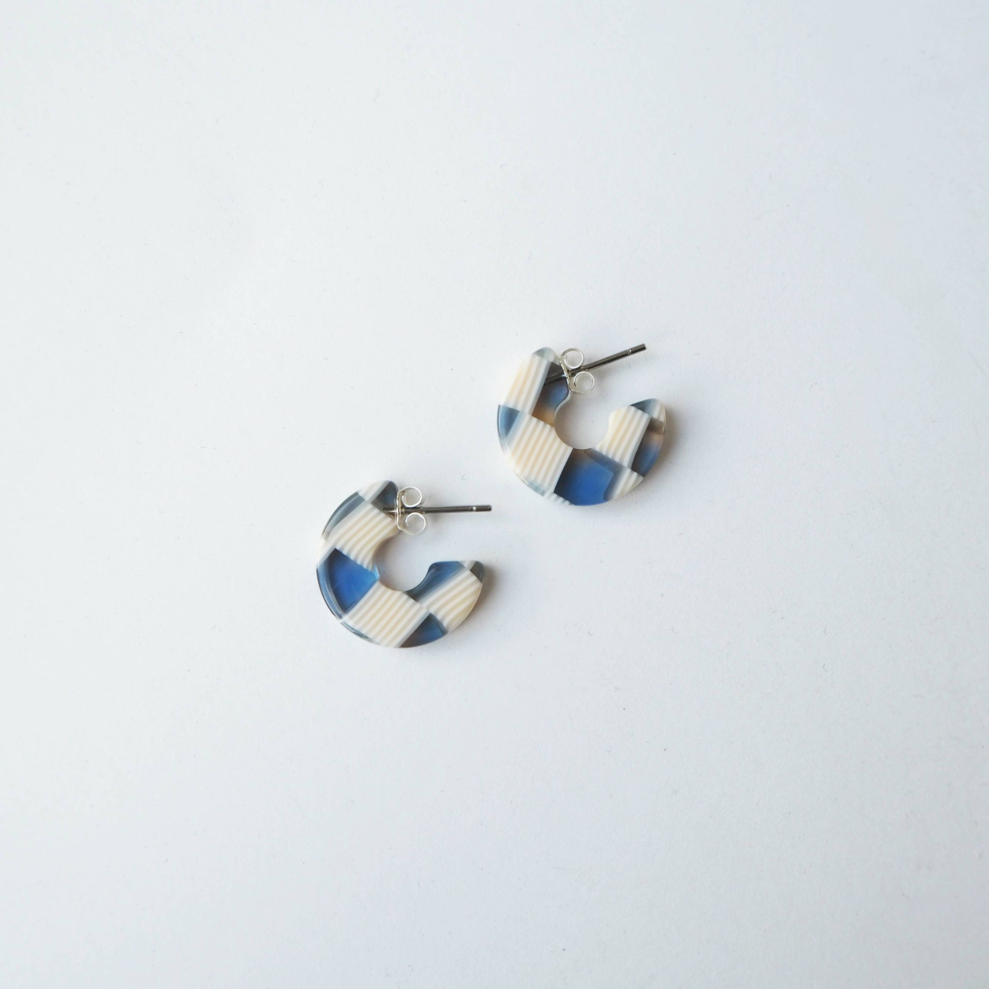 Close up of blue and cream checkerboard mini hoop earrings