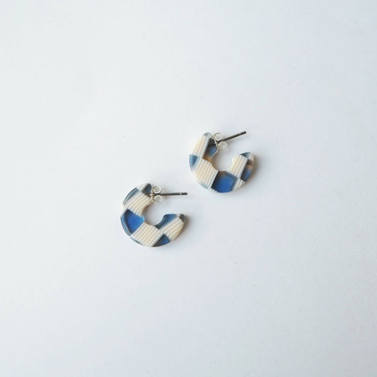 Close up of blue and cream checkerboard mini hoop earrings