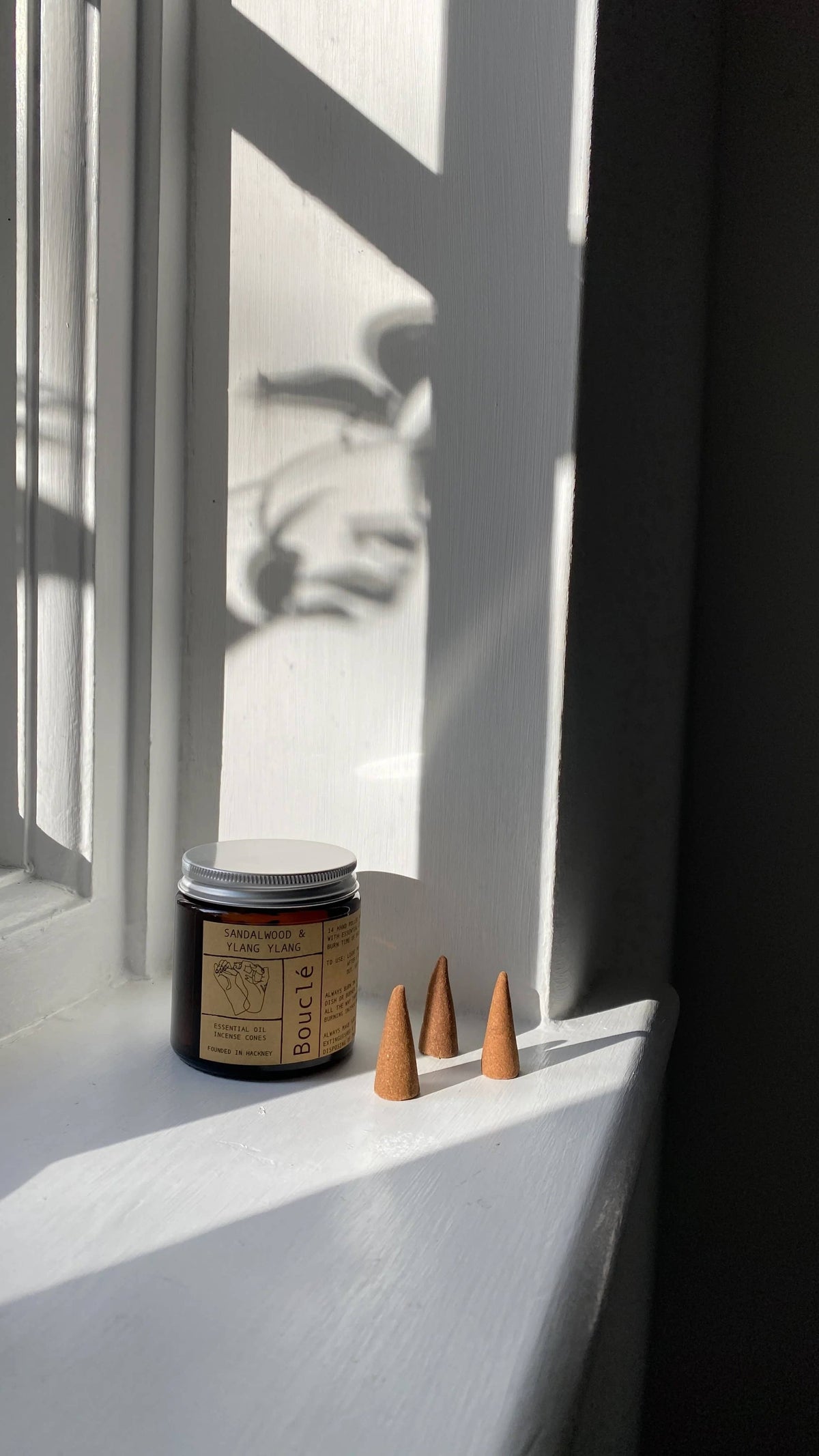 Hand-rolled natural incense cones spilling from a glass jar