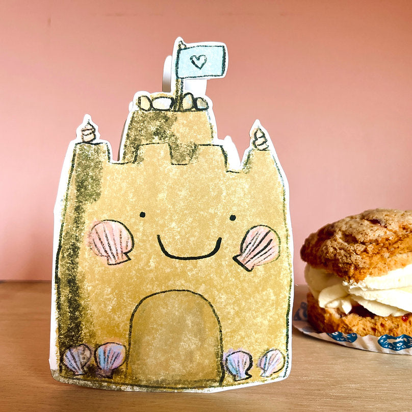 Bright and cheerful Happy Sandcastle illustration on a 100% recycled card with gold foil accents, perfect for a child's birthday.