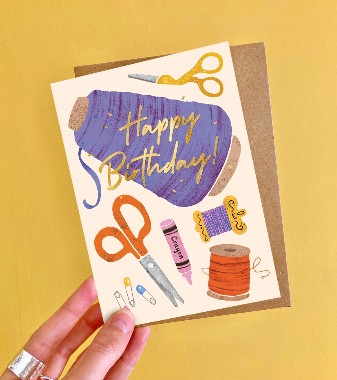 Birthday card with sewing-themed illustrations on a yellow background