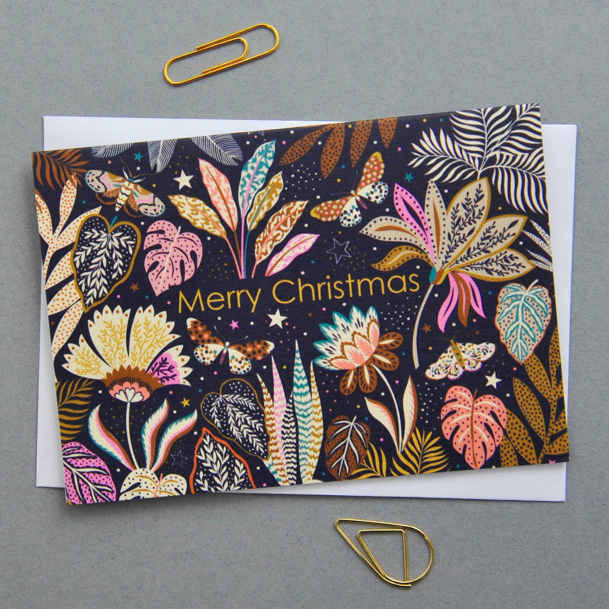 Christmas notecard with vibrant flora and fauna illustration on a dark background, 'Merry Christmas' text.