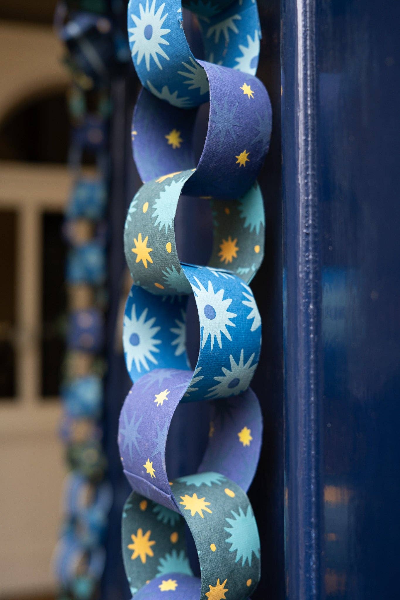 Detail of an assembled blue and yellow recycled paper chain pattern