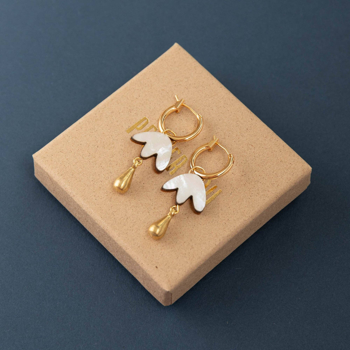 Side profile of handmade petal drop hoop earrings