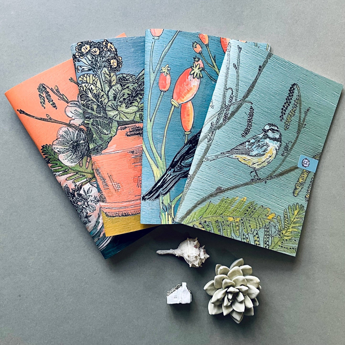 A selection of Lilly Faith's  A5 Notebooks, which are illustrated with birds and flora.