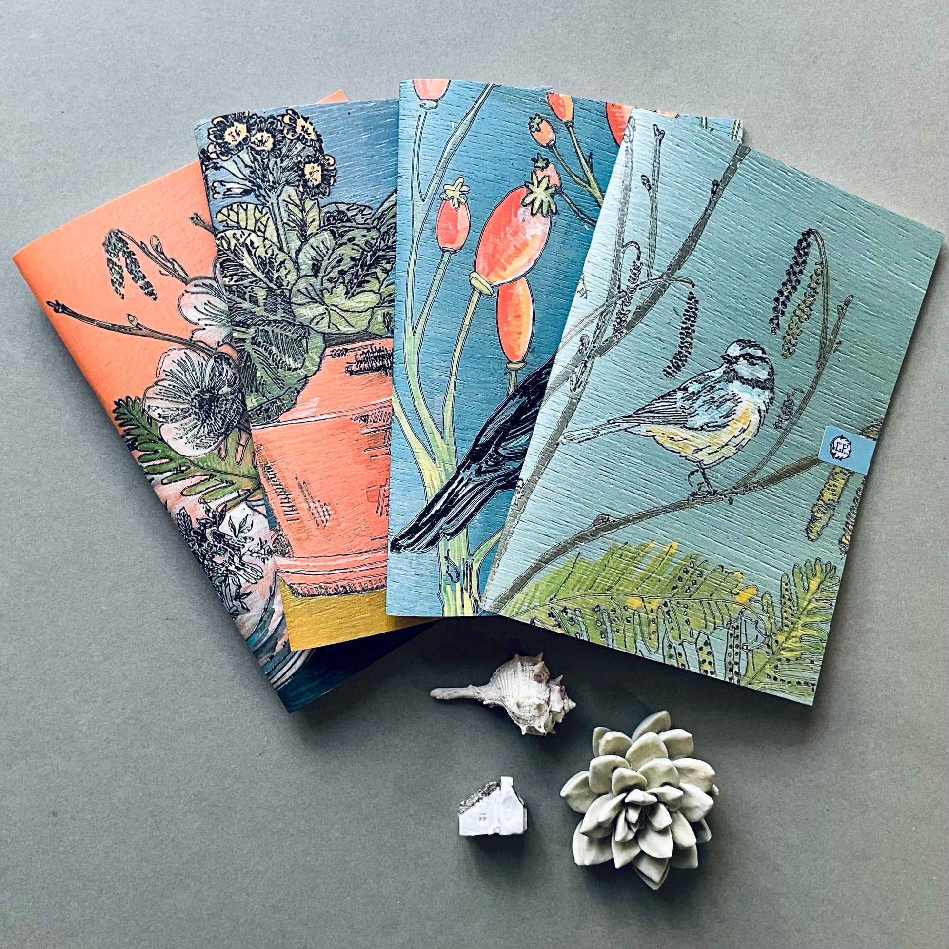 A selection of Lilly Faith's  A5 Notebooks, which are illustrated with birds and flora.