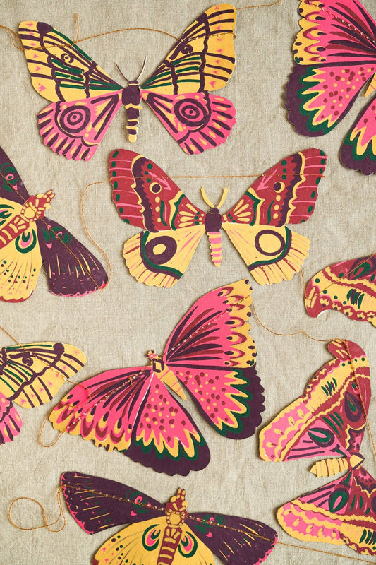 Colourful hand-printed butterfly garland hanging on a wall