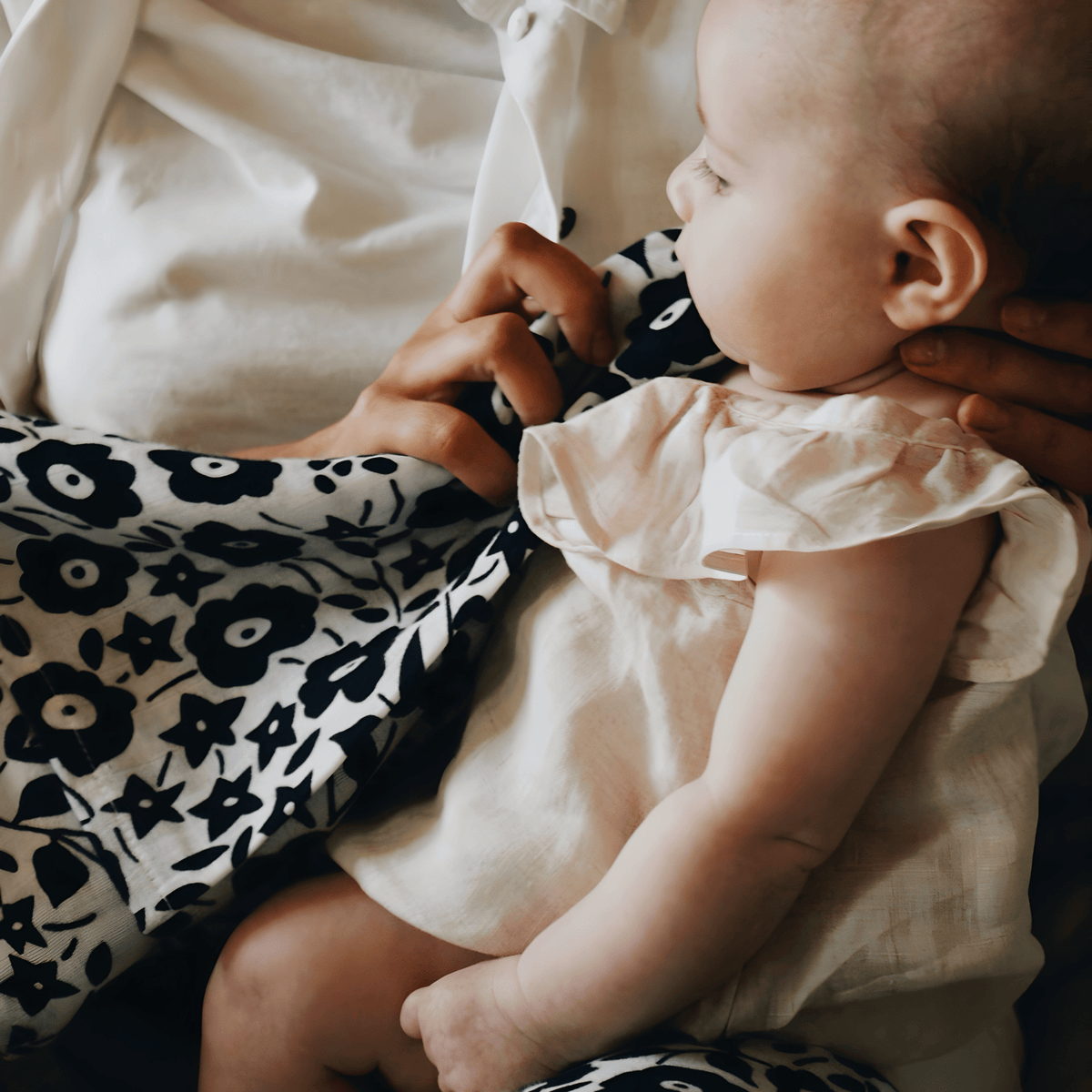 Baby looking at Etta Loves x Liberty sensory muslin swaddle