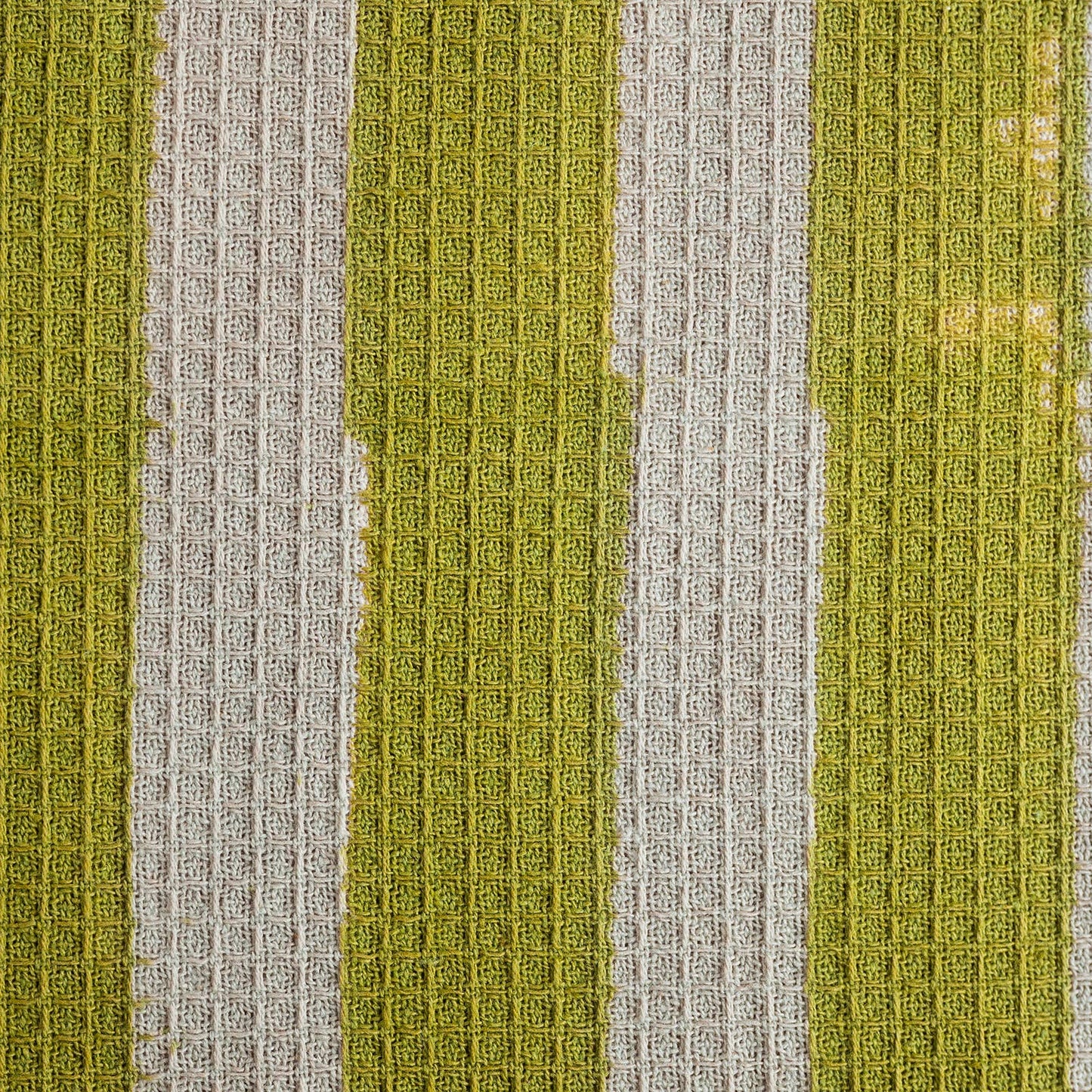 Close up of hand block printed olive stripe pattern on waffle cotton