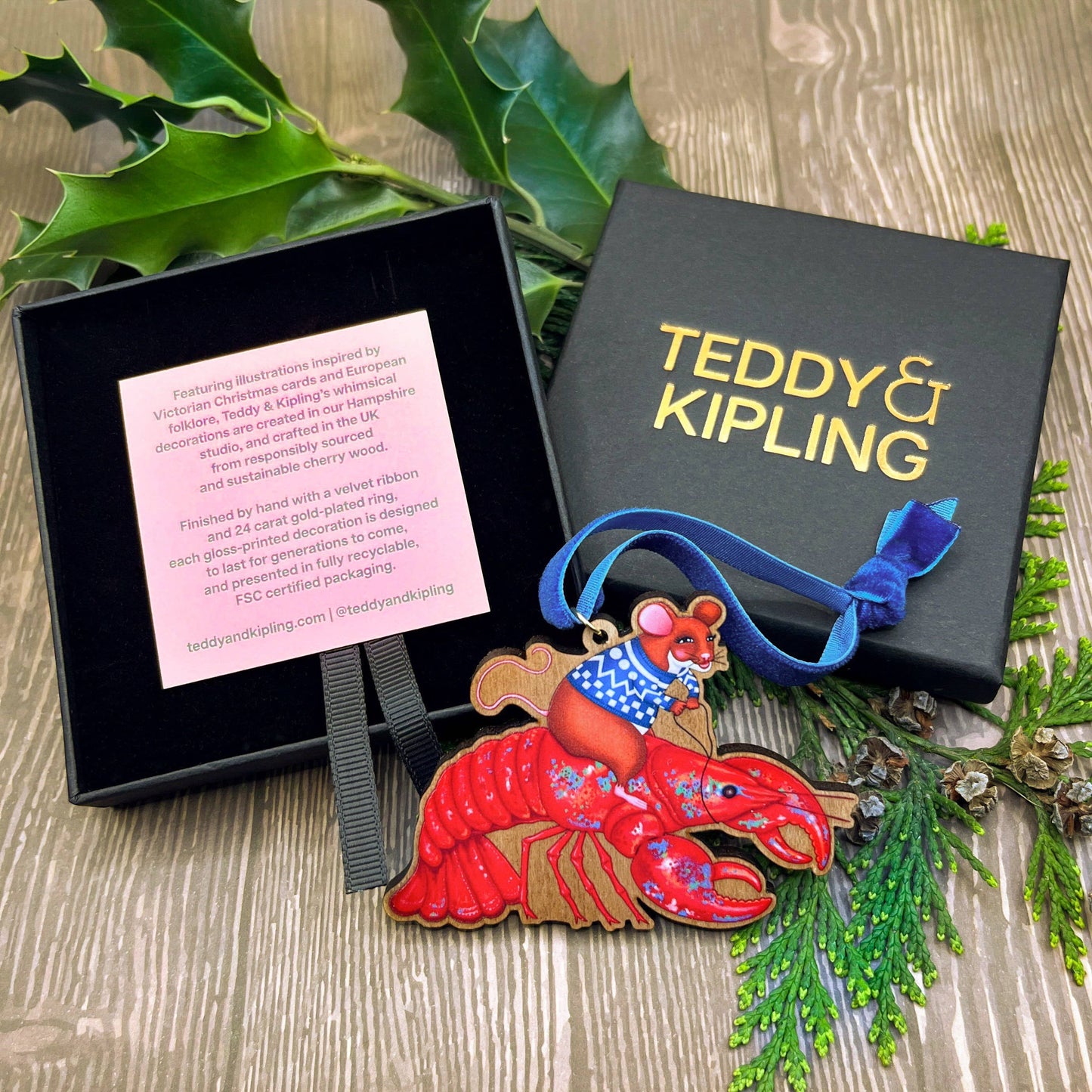 Mouse On A Lobster wooden Christmas tree decoration with Teddy & Kipling illustration, sustainably certified cherry wood, gold-plated ring, and royal blue velvet ribbon.