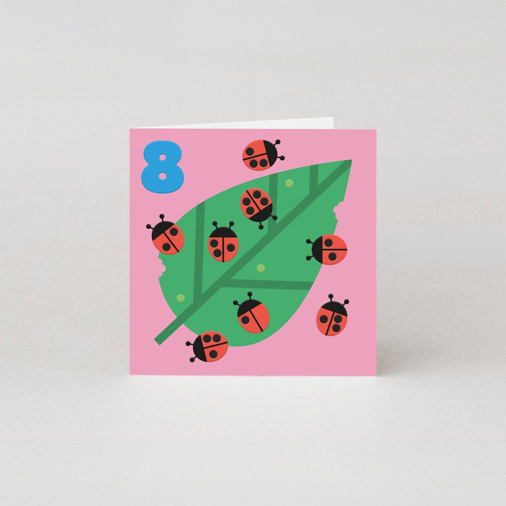 Studio Boketto 8th Birthday Card, embossed ladybirds on green leaf, bright blue number 8, 300gsm sustainably sourced paper, red envelope, UK made