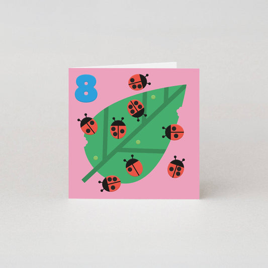 8th birthday card by Studio Boketto with embossed ladybirds on a green leaf, bright blue number 8, sustainably sourced 300gsm paper, UK made