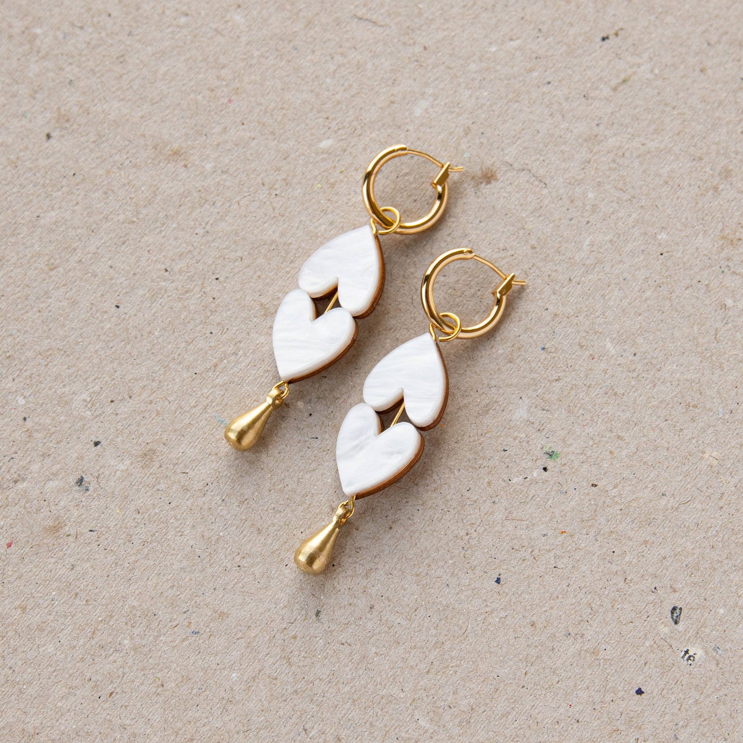Detailed view of brass teardrop on heart earrings
