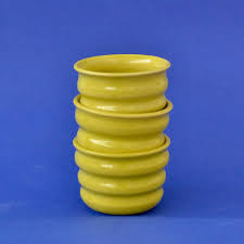 Handcrafted Ripple Beaker in Chartreuse. Handcrafted from stoneware clay, this colourful ceramic beaker with distinctive ripple texture is ideal for your morning coffee, a wine with friends or even a good old cup of water. The quirky rippled form provides a playful aesthetic whilst also being extremely ergonomic to hold, perfect for slotting your fingers comfortably into the grooves. 7 cm high and 9cm wide at the rim.