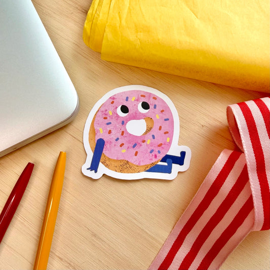 Brighten up your everyday items with this adorable pink doughnut vinyl sticker, beautifully illustrated by Emily Nash.