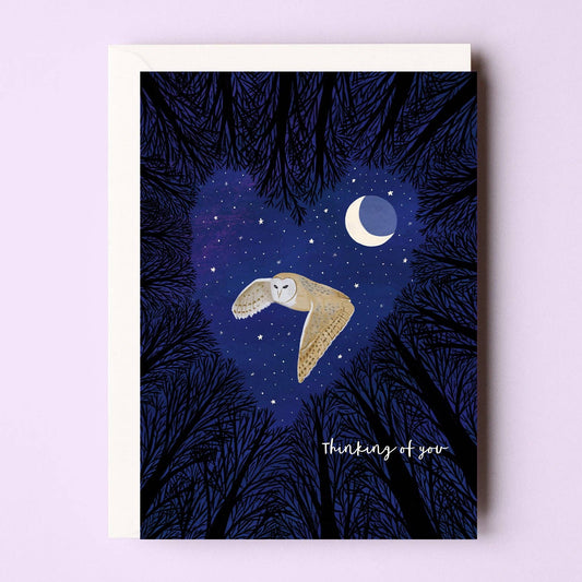 Thinking of you card. This greeting card features a flying barn owl against a moonlit forest backdrop. Let your loved ones know they are thought of with this heartfelt design.