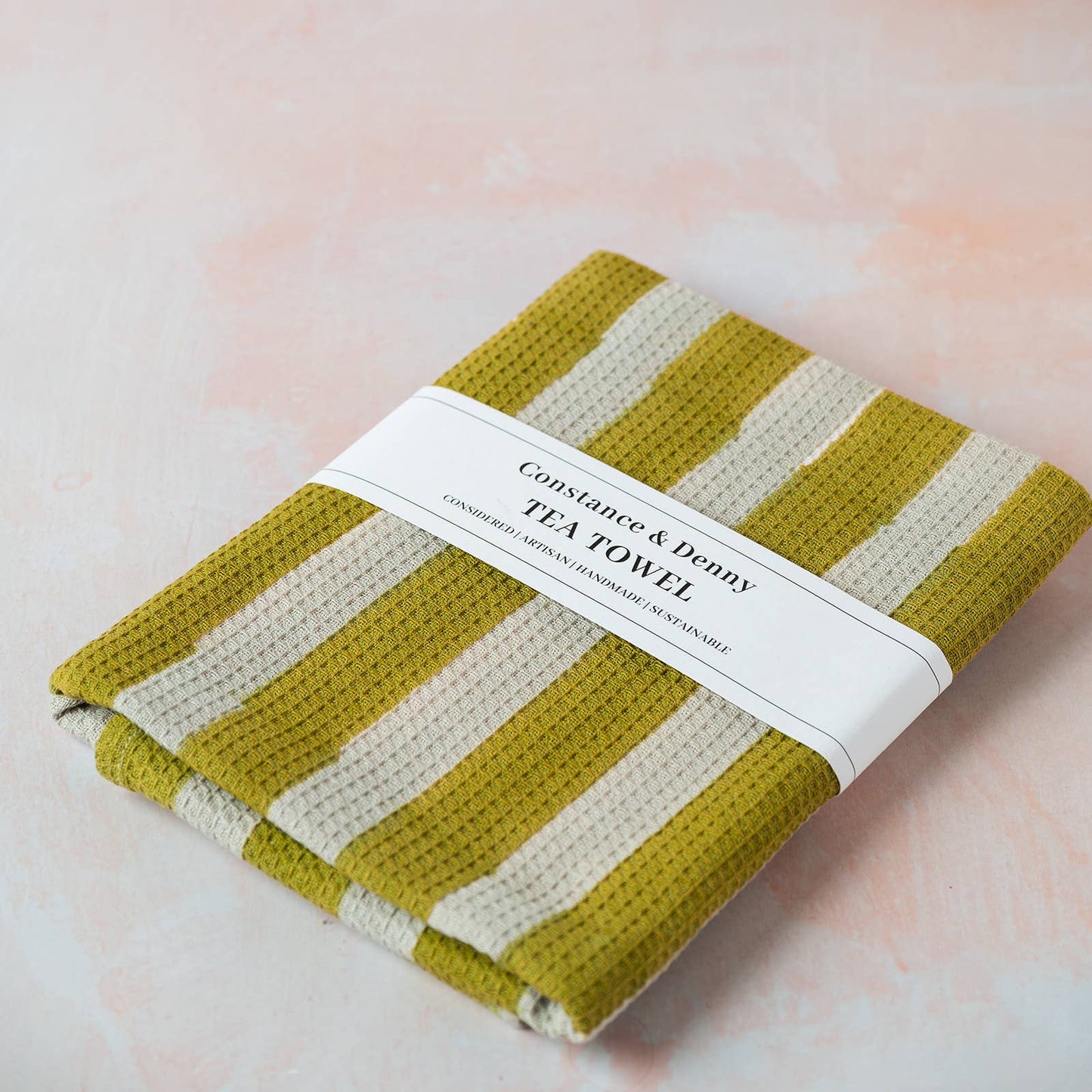 Olive wide stripe waffle cotton tea towel hanging in a kitchen