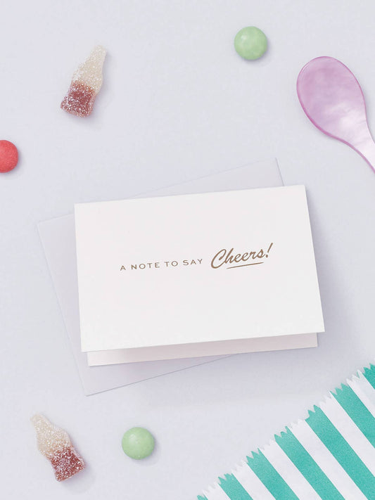 Inspired by Retro Americana typography, this pocket-sized card is great to have on hand for a quick thank you note. Featuring the words "A Note To Say Cheers!" beautifully hot foil pressed in gold, each card is created by hand in Another Loop's small studio.