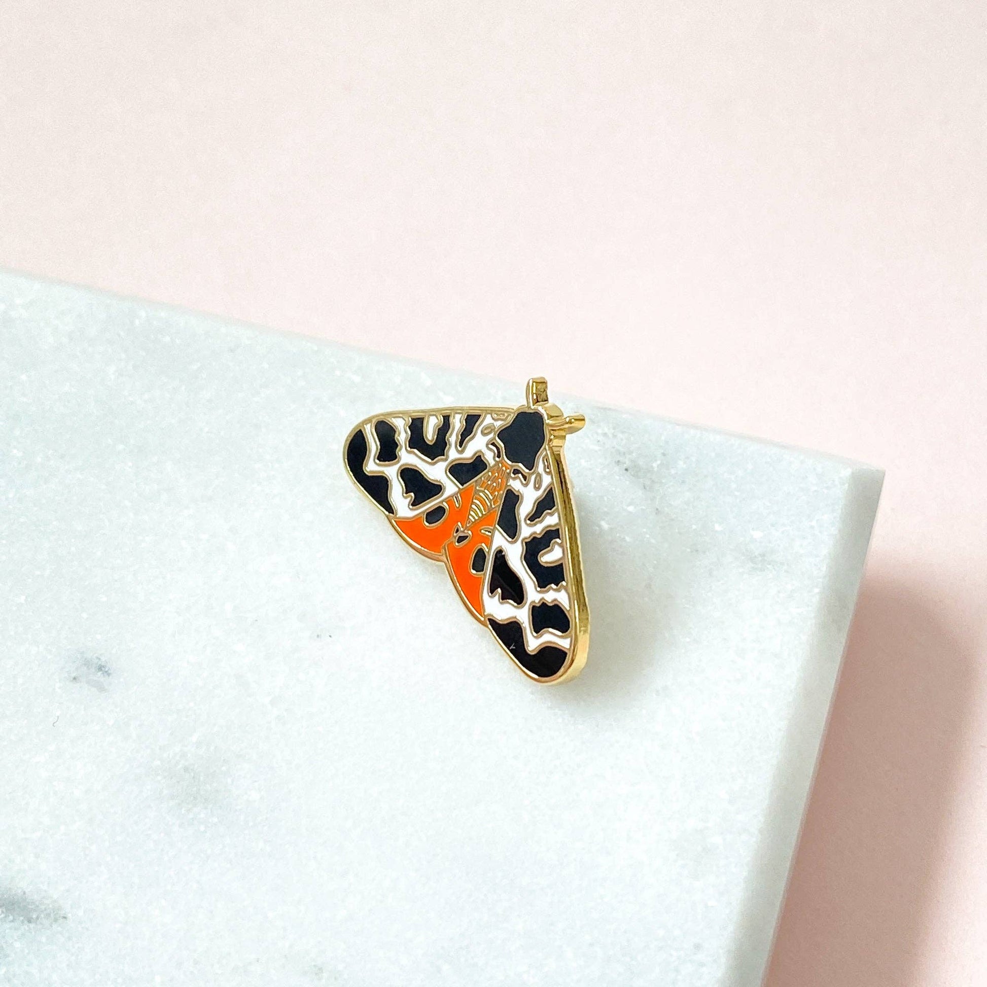 Tiger Moth Enamel Pin by Sarah Frances, 1 inch gold metal with hard enamel red and black garden moth design, pink rubber clutch back.