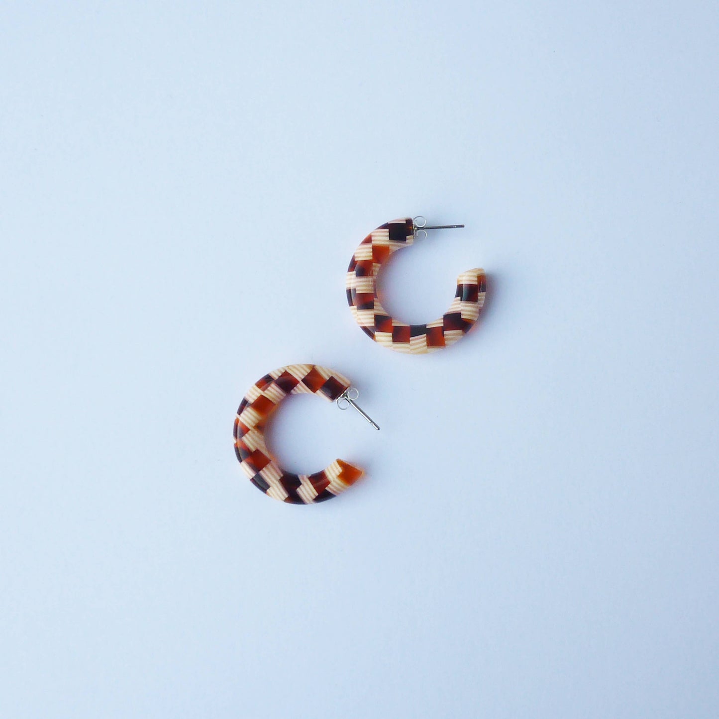 Pair of honey mix checker hoop earrings on a white background