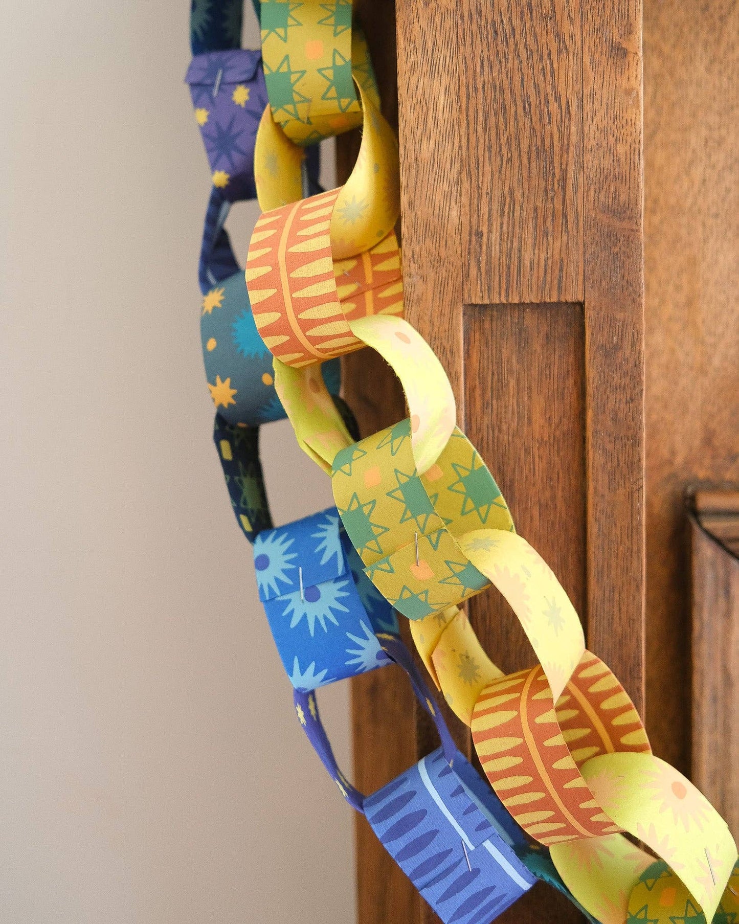 Assorted yellow and green patterned recycled paper chain strips
