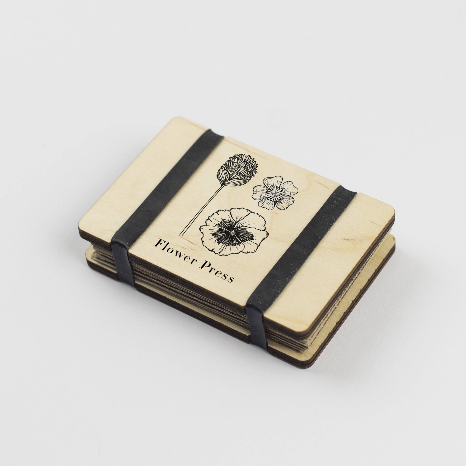 Pocket Flower Press made from sustainable maple veneered wood with corrugated card and sugar paper sheets, silicone rubber bands; pocket-sized and handmade in England.