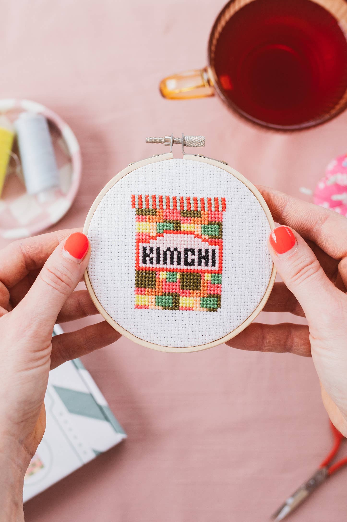 Close-up of the finished Kimchi cross stitch design, showcasing detailed stitching of the fermented condiment in an 11cm wooden hoop.