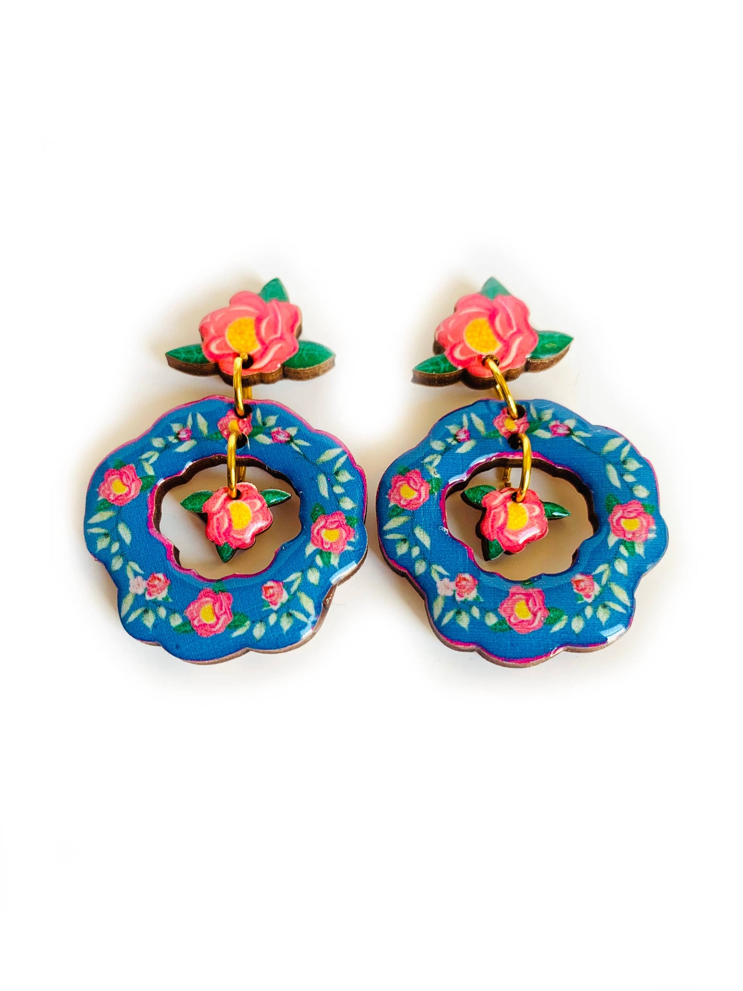 Blue floral flower drop earrings which are double dangle. With a with a mini flower in the middle compartment. Blue colour with pink hues and flowers. Laser cut wood and lacquered with clear resin.