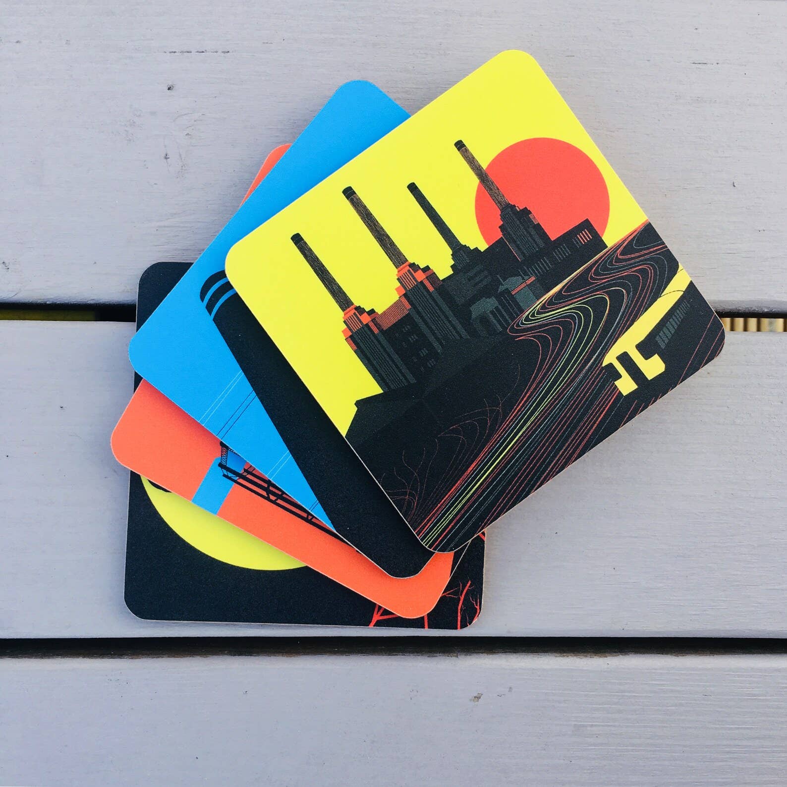 Industrial London Coaster Gift Set. Set of 4 coasters featuring London Landmarks. Battersea, Hackney, Croydon and Brick Lane Gasholders and chimneys. The gritty, not so pretty side of industrial London. Featuring the Battersea Power station, the gasworks at Waddon Marsh Croydon, the chimney of the Old Truman Brewery, and the gas holders by the canal in Hackney, as seen from an overground train. The coasters come in a smart black box, with the words Industrial London Coaster Set in white font.
