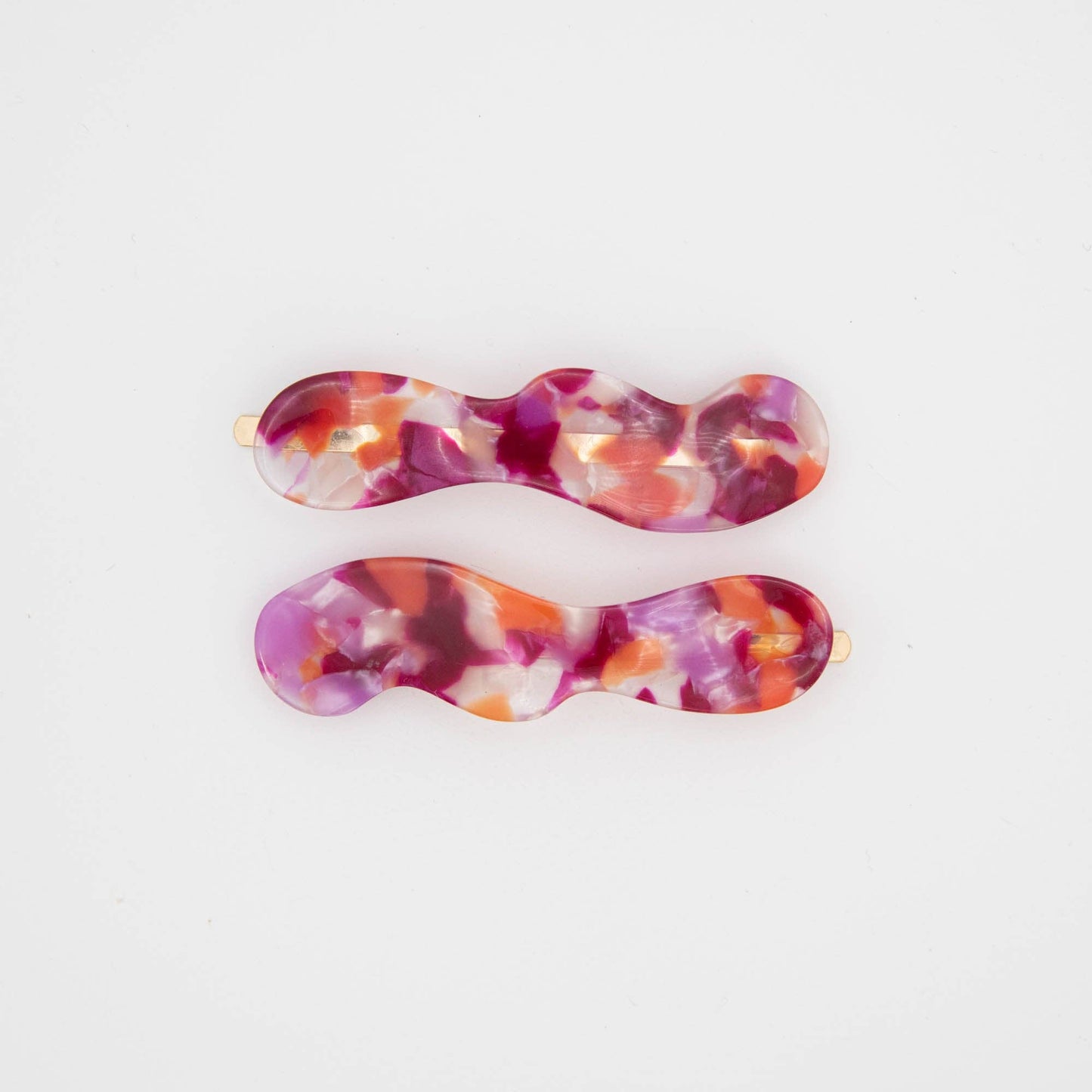 Set of two berry coloured hair slides on a white background