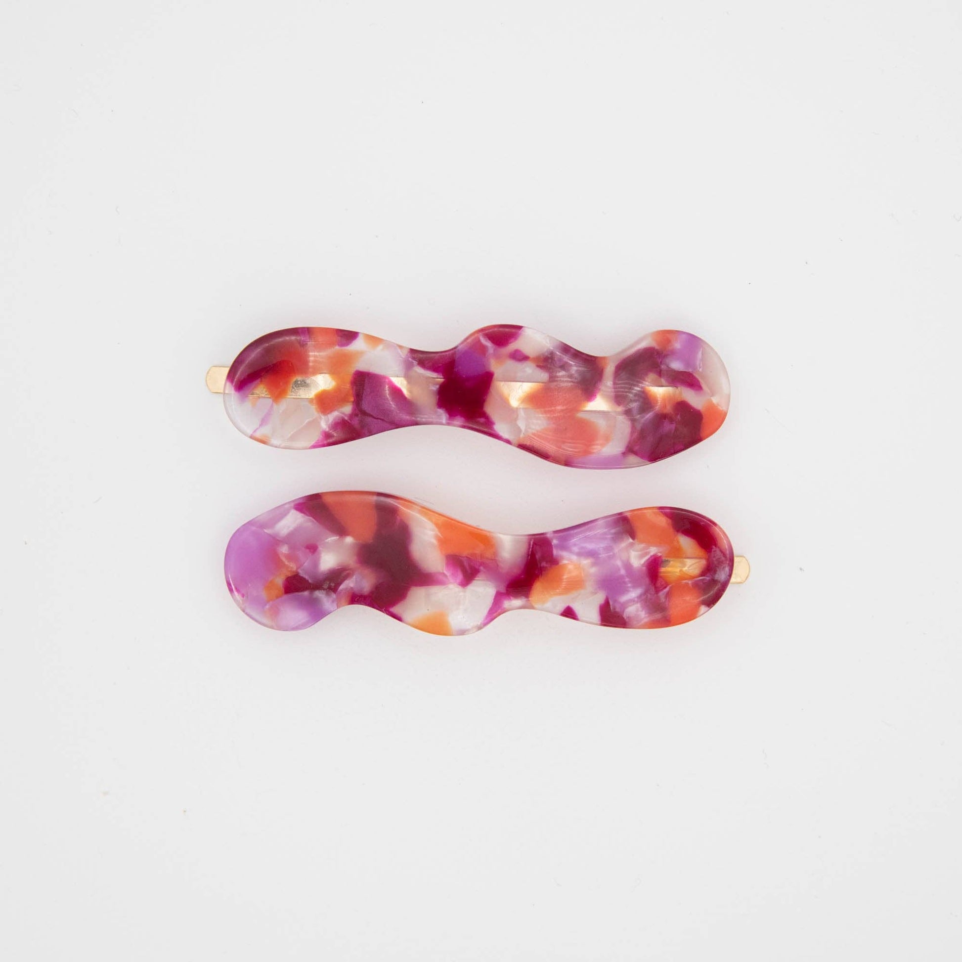 Set of two berry coloured hair slides on a white background
