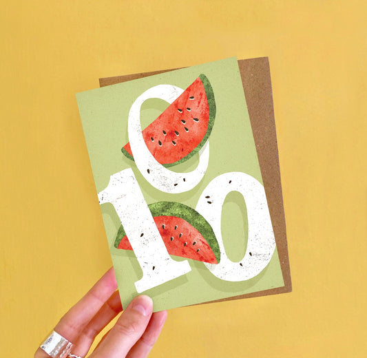 A6 100th birthday card featuring a colourful watermelon-themed illustration and ‘One Hundred’ caption by Emily Nash, printed on premium matte card with kraft envelope.