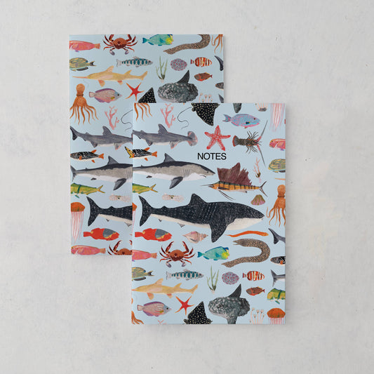 A5 sea life notebook featuring hand-illustrated ocean animals on a blue background, matte finish cover, and kraft belly band. Eco-friendly, UK made.