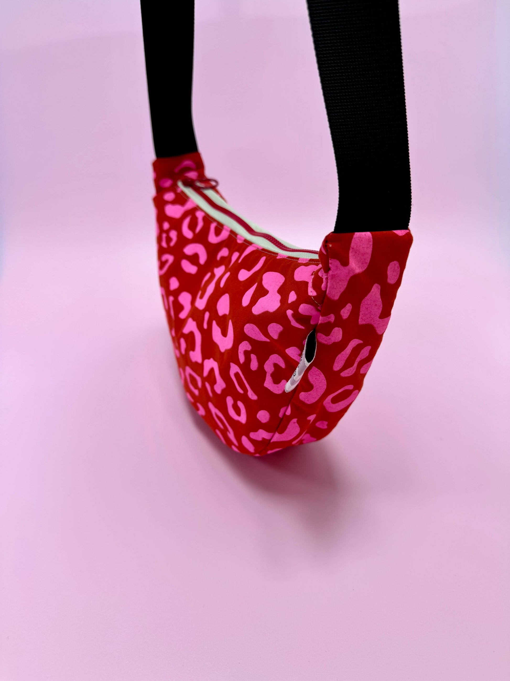 Close up of handprinted leopard pattern on red waxed canvas