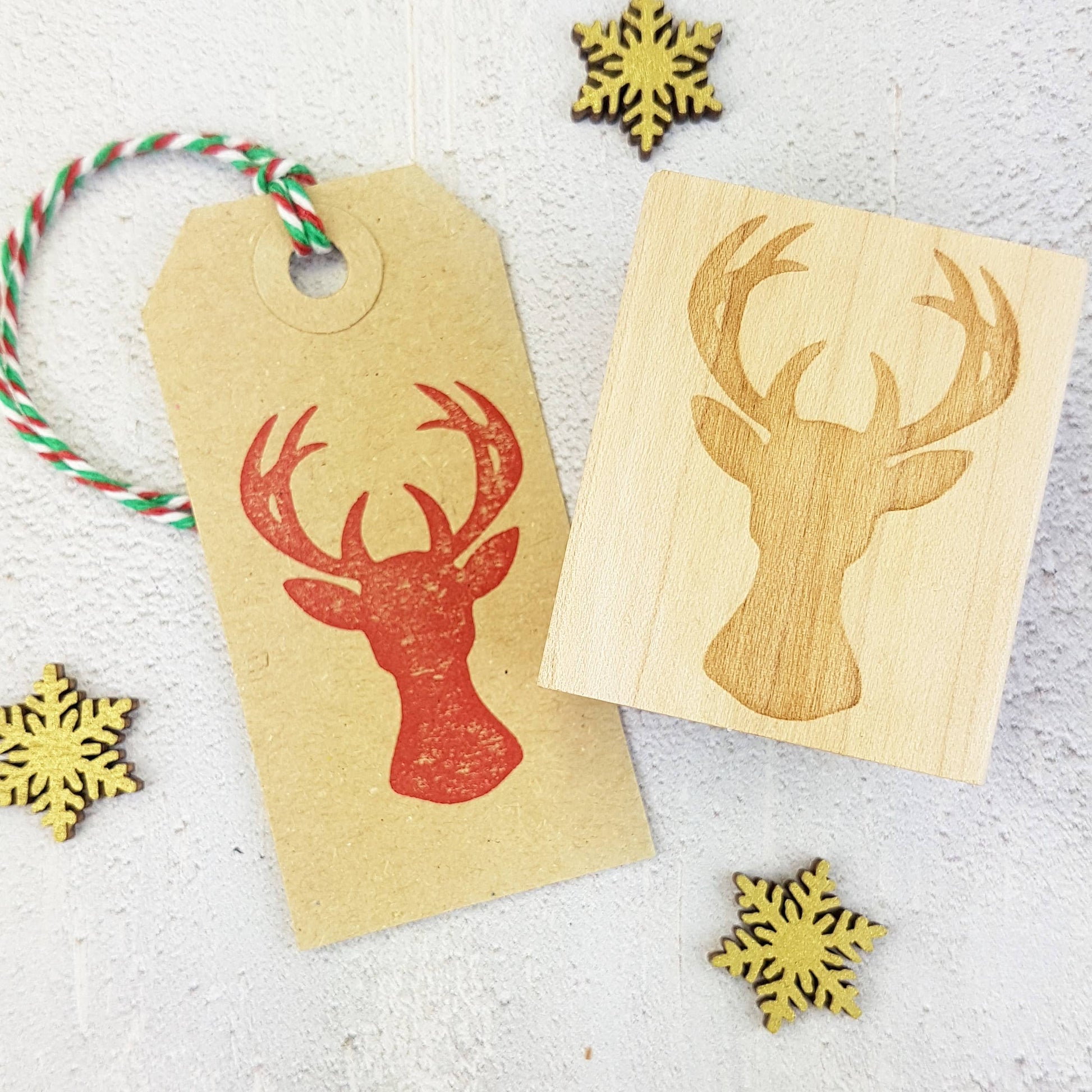 Rustic Christmas stag head rubber stamp mounted on eco-friendly hourglass wooden block, ideal for sustainable holiday cards and gift wrapping, handmade in Devon UK