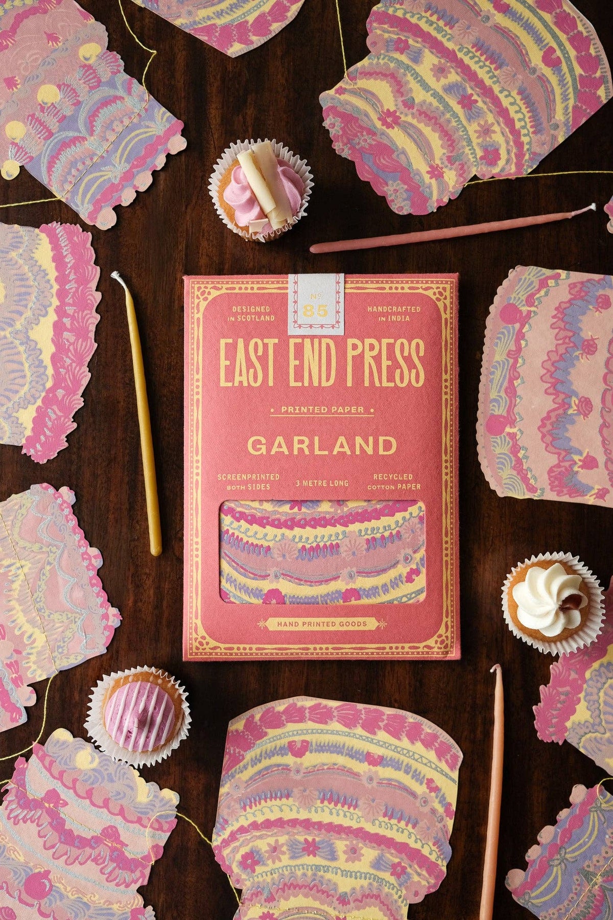 Frosted birthday cakes sewn paper garland close-up