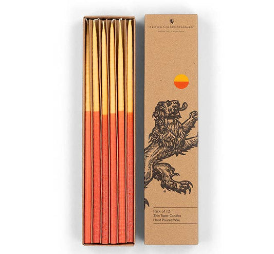 Two-tone saffron and rust thin taper candles in a kraft card box