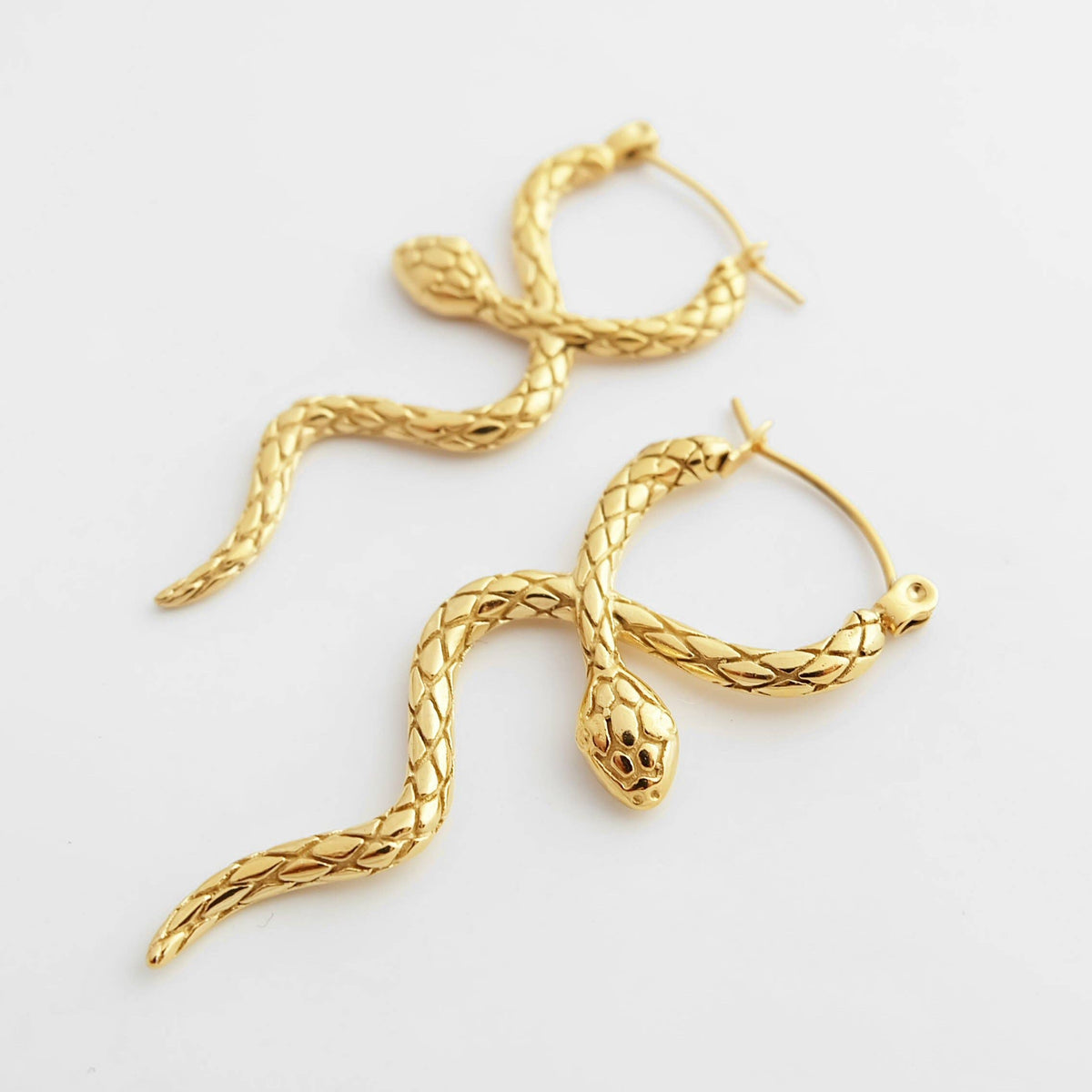 Gold snake hoop earrings with detailed serpent design