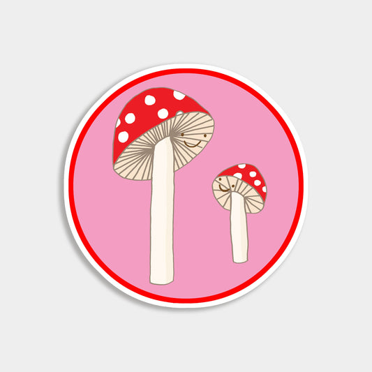 Hand-drawn magic mushroom vinyl sticker on soft pink background, featuring large and small fly agaric toadstools smiling at each other. Cottagecore, fairycore, nature aesthetic.