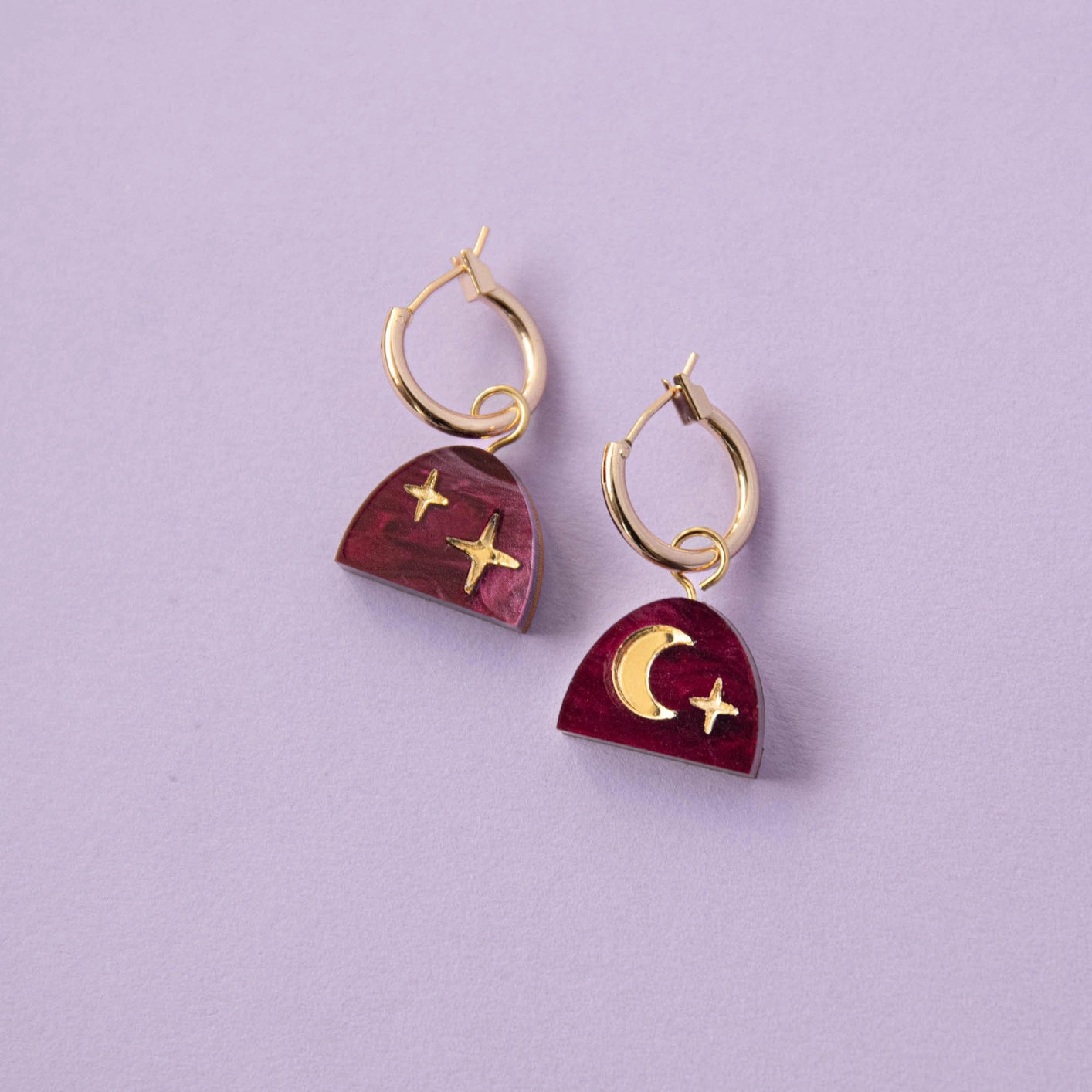Close-up of Mini Moon Rising Arc Hoop Earrings in merlot red marble and sustainably sourced wood, showcasing the 15mm gold plated brass hoops.