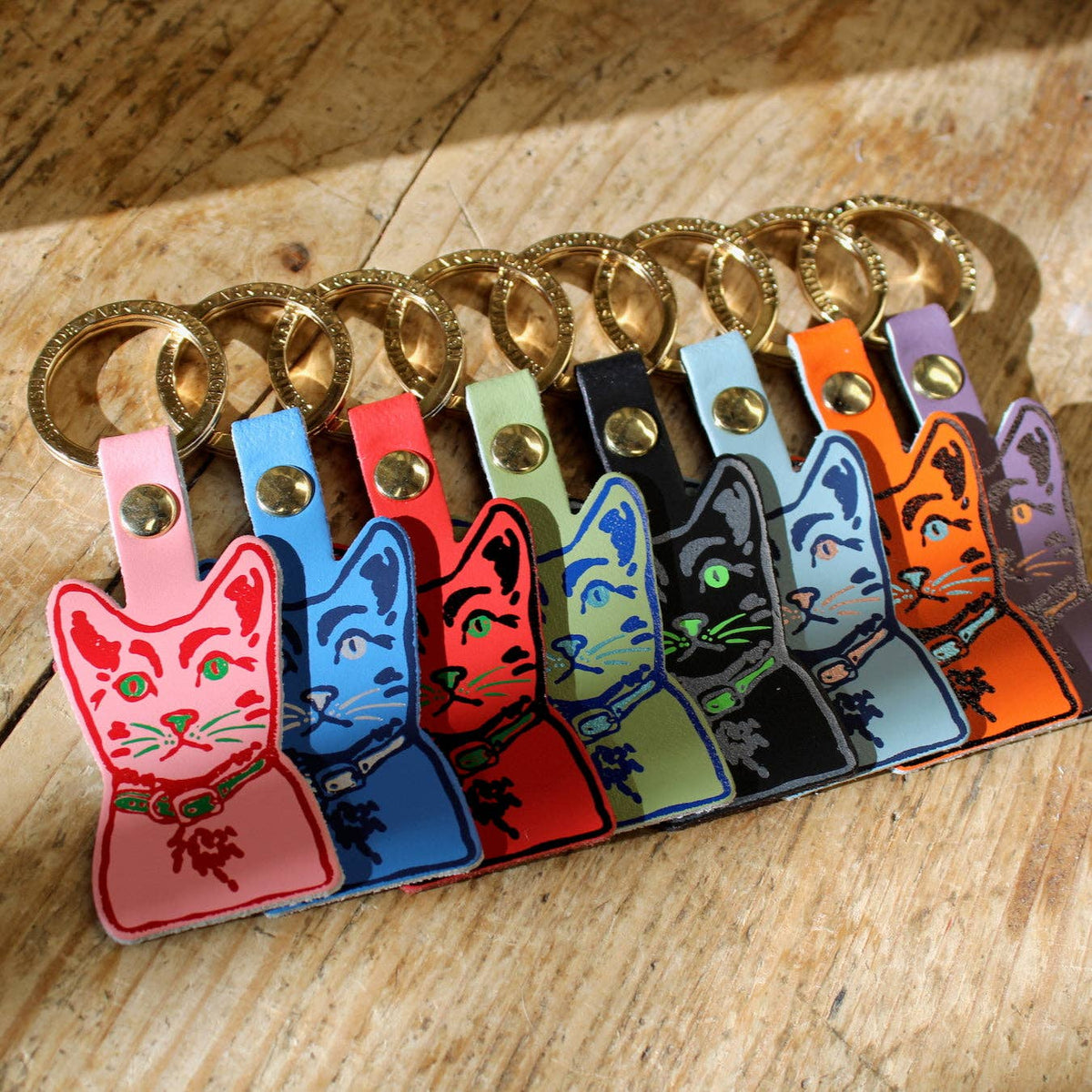 Tabby cat leather keyring with gold plated ring on neutral background