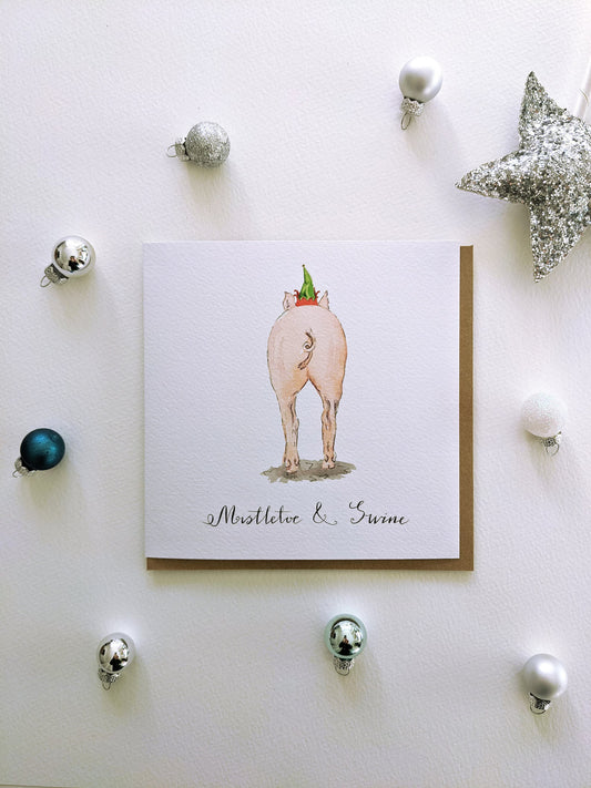 Mistletoe & Swine Christmas greeting card featuring a charming pig in an elf hat, a humorous and festive design by Jessica Kendrew.