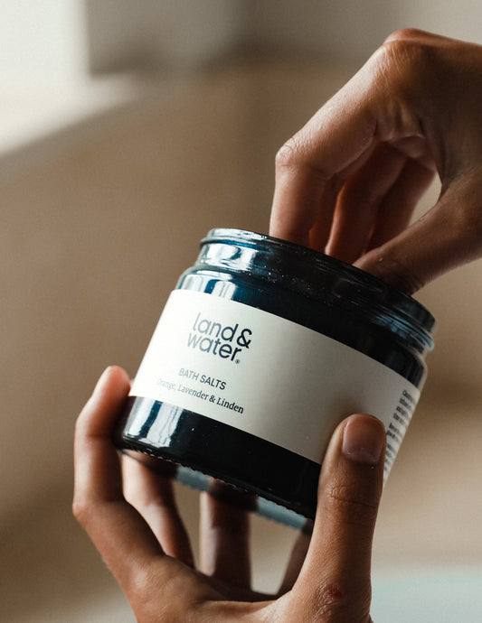 Close-up of Orange, Lavender & Linden Bath Salts in blue jar, showcasing natural texture.