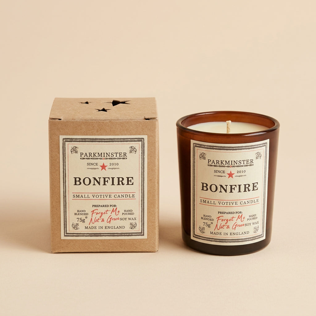 A Bonfire candle by Parminster shown with its amber glass jar and matching beige cardboard box, photographed on a neutral surface.