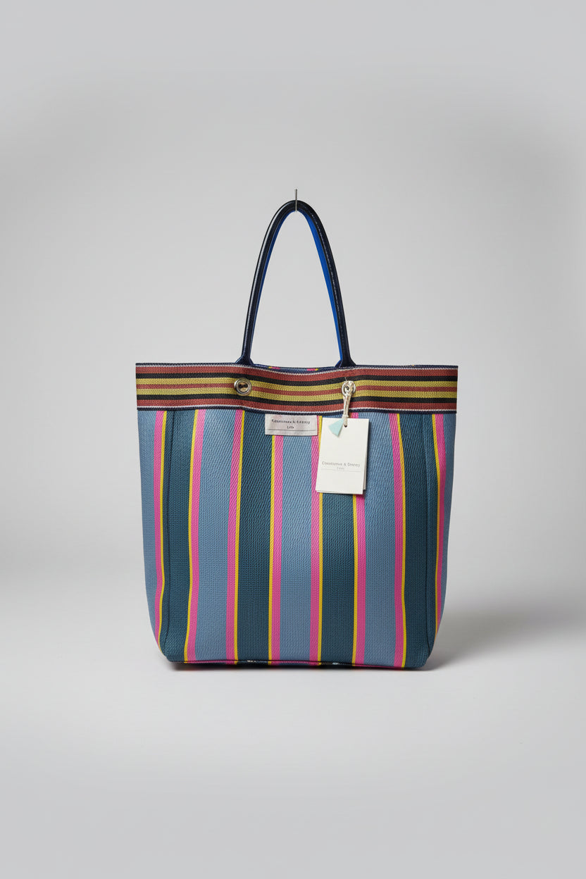 A striped tote bag with blue, pink, yellow, and green horizontal stripes, with a metal handle and shoulder strap