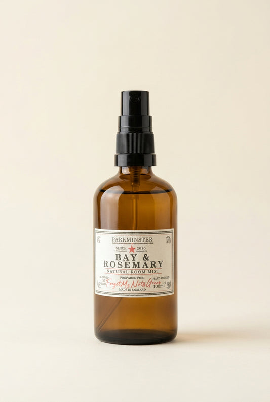 A bottle of Bay & Rosemary room spray by Parkminster, in an amber glass bottle with a black spray nozzle and a white label. Natural, vegan and made in Cornwall.
