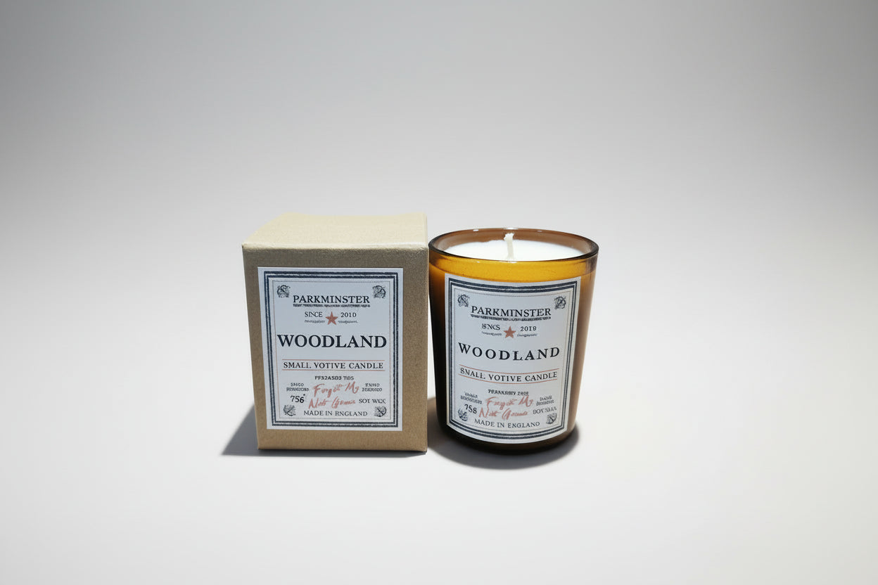 Candle in a glass jar with a label on a cardboard surface Woodland Parkminster Votive with kraft box