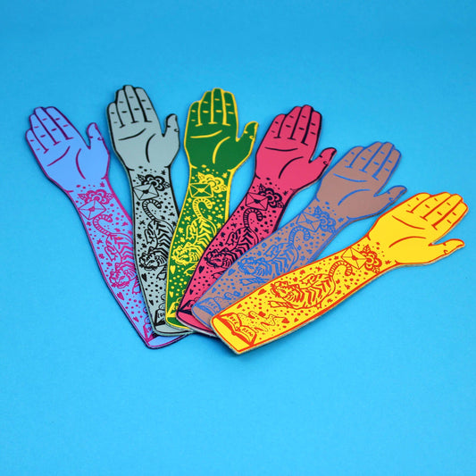 Close-up of a genuine leather bookmark featuring a colourful tattooed arm design, handcrafted in Scotland.